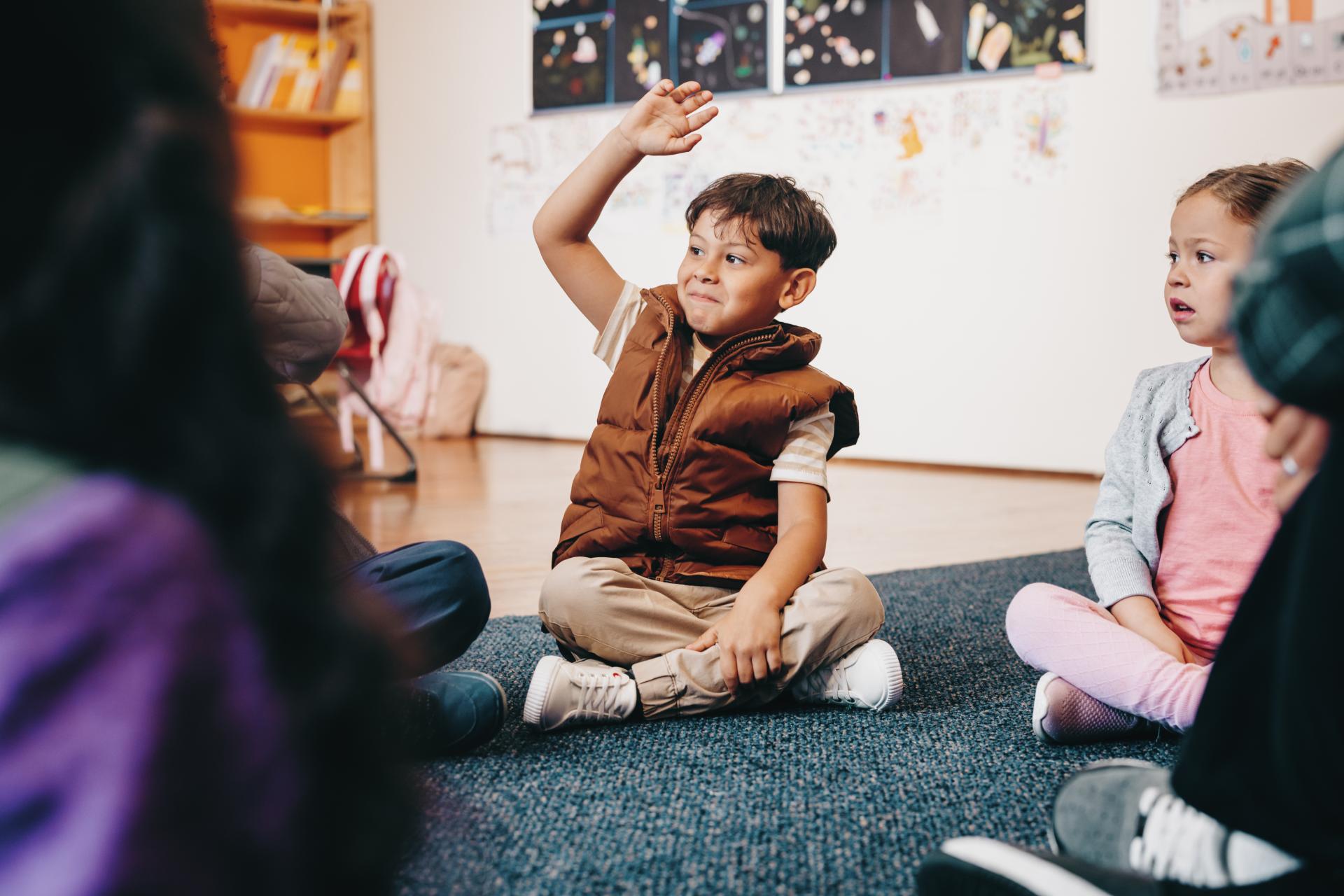 Kid raising hand in a group